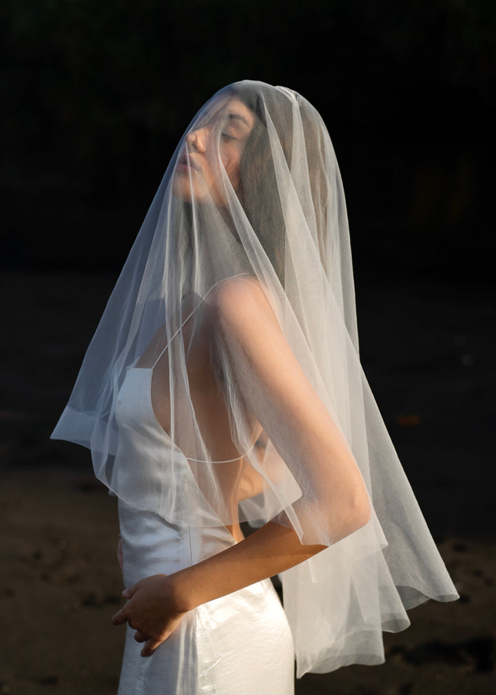 Woman in a white dress with a short simple plain classic veil in full coverage