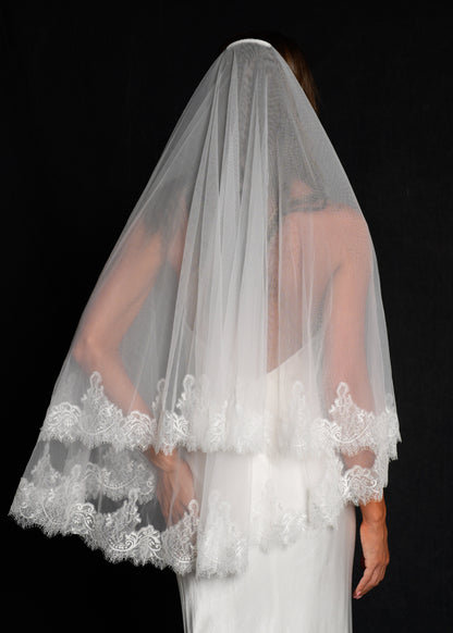 Back view of bride wearing a chantilly short lace veil, two tier, fingertip length cascading down
