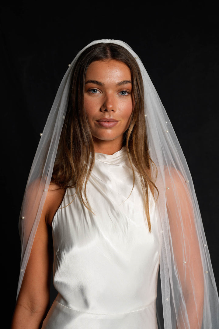 Woman wearing a white dress and pearl veil